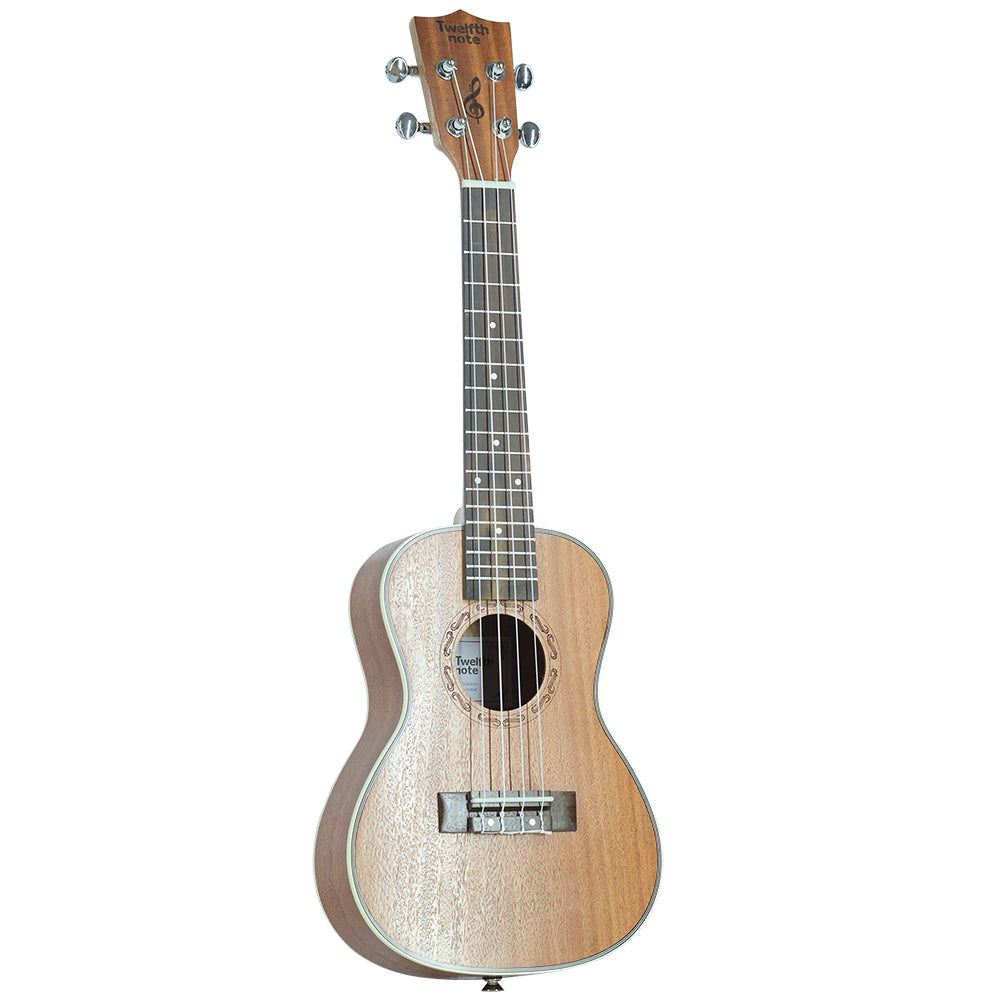 Three-quarter angle view of Twelfth Note Crafted Series ukulele showing the natural wood grain top, soundhole motif, and fretboard